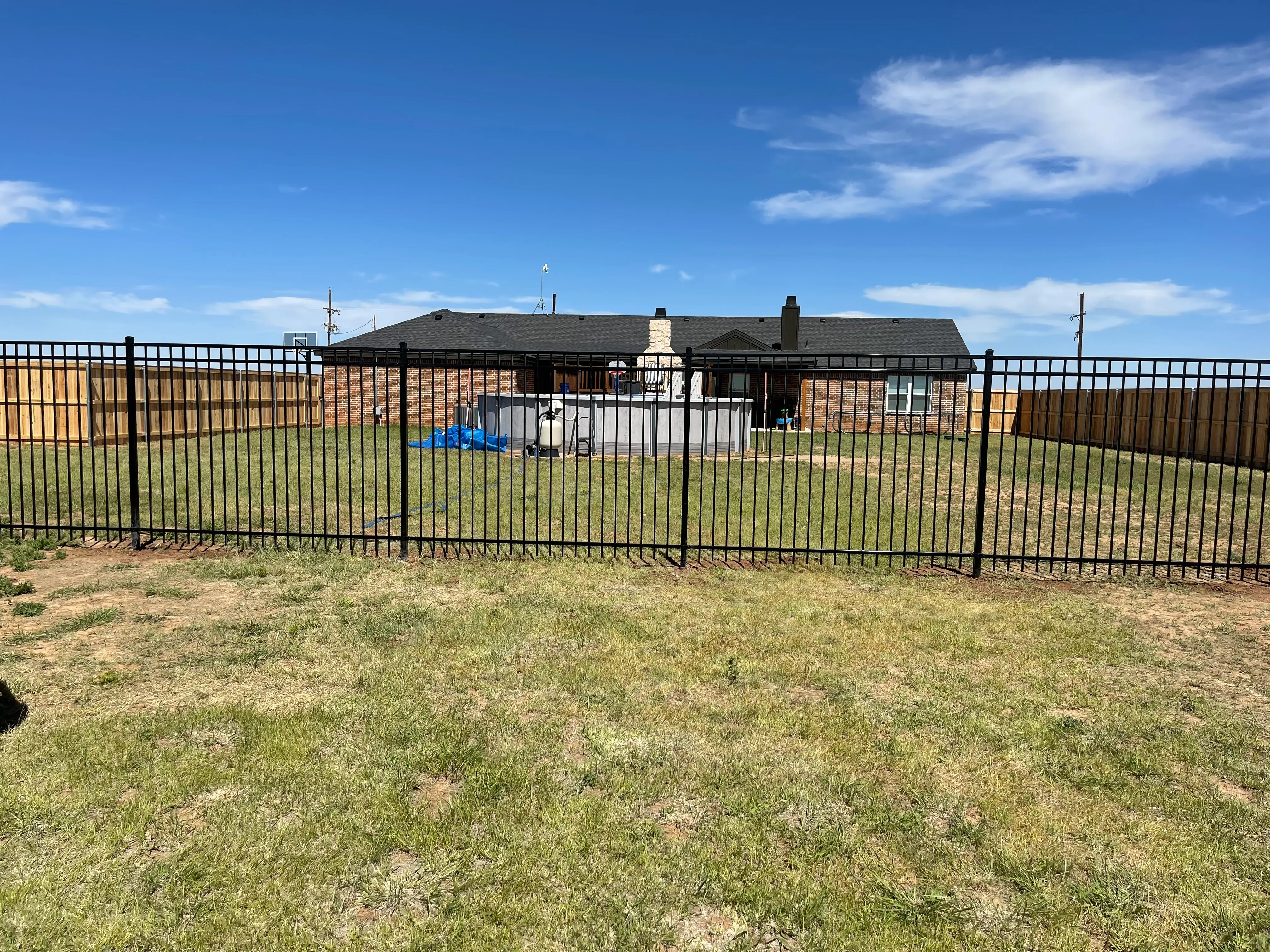 Long-run welded iron fence used as backyard perimeter divider