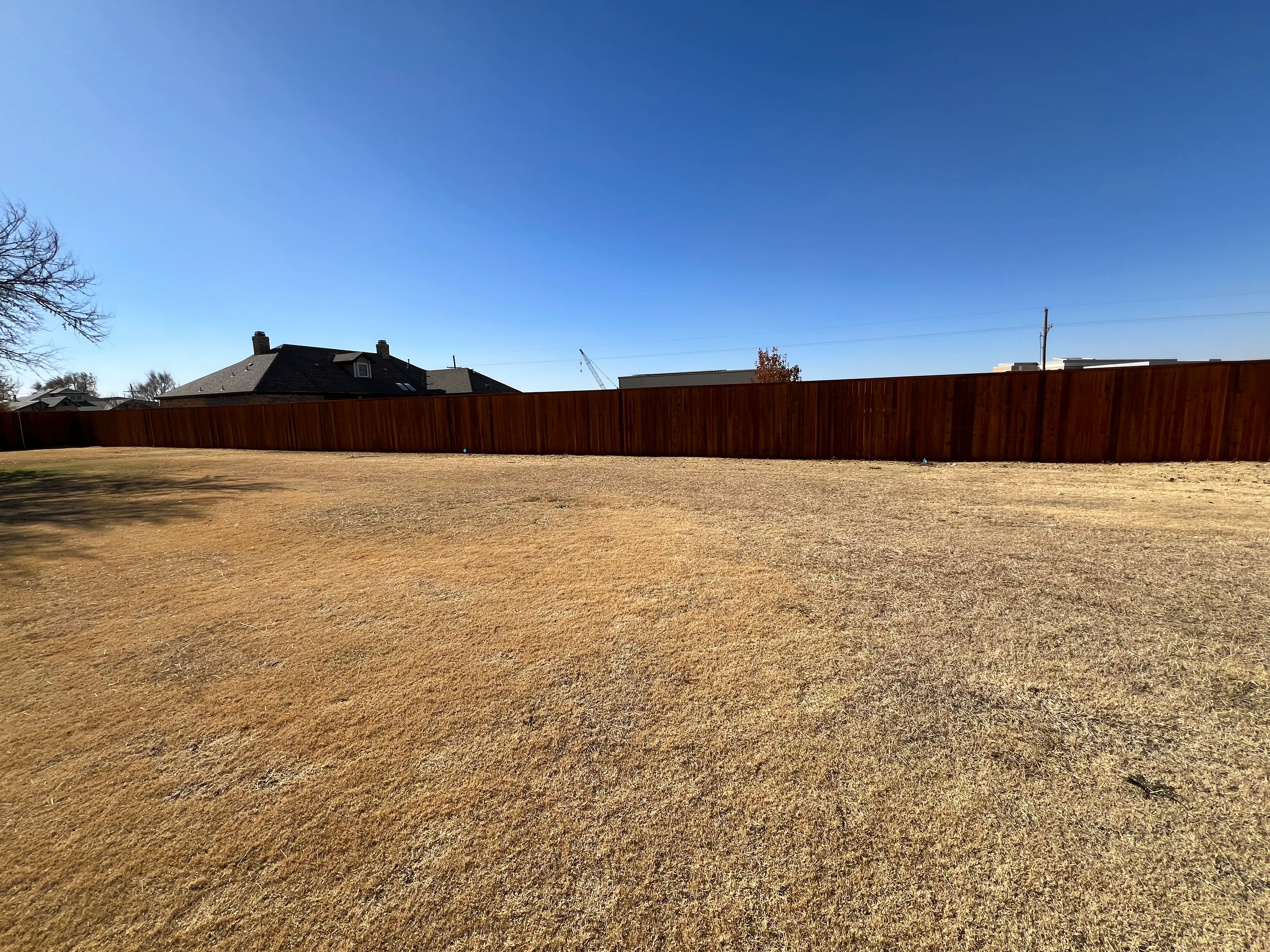 Cedar privacy fence spanning large rural lot in Keller Texas