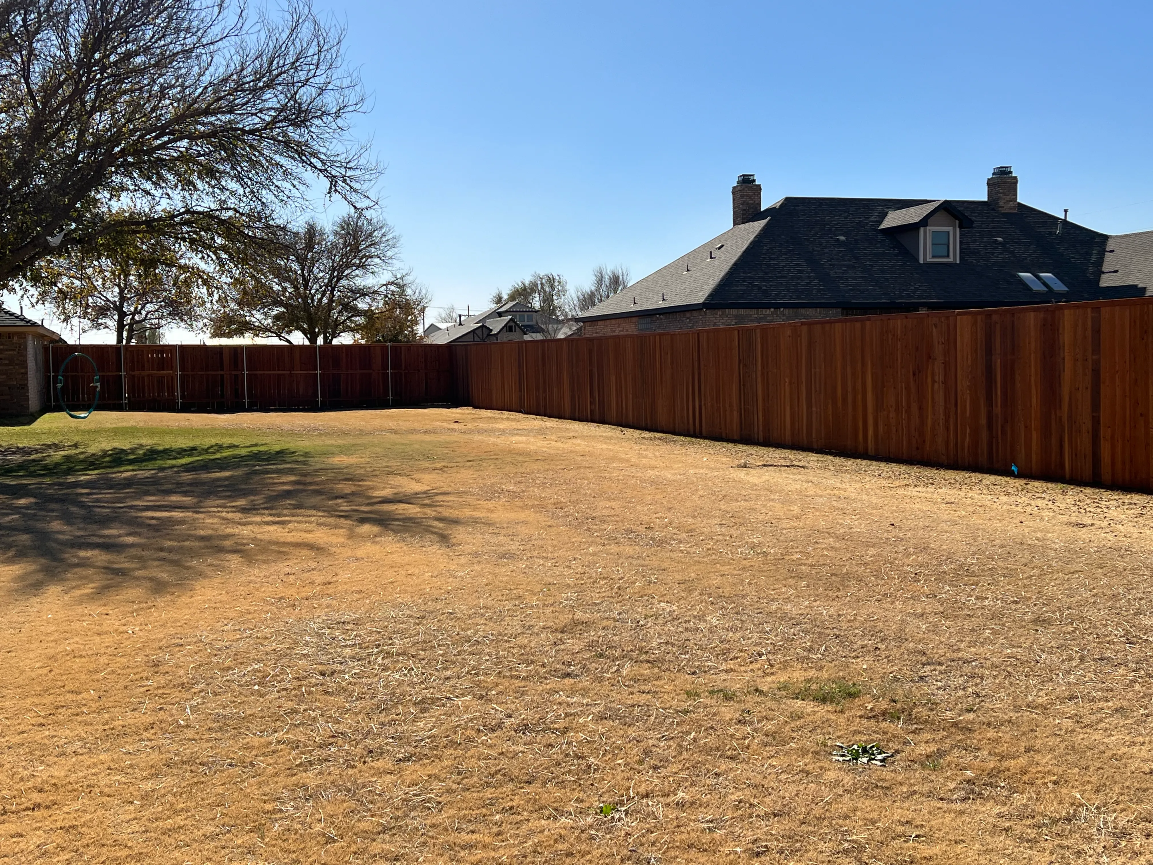 Cedar privacy fence finished with cedar-tone stain for UV protection