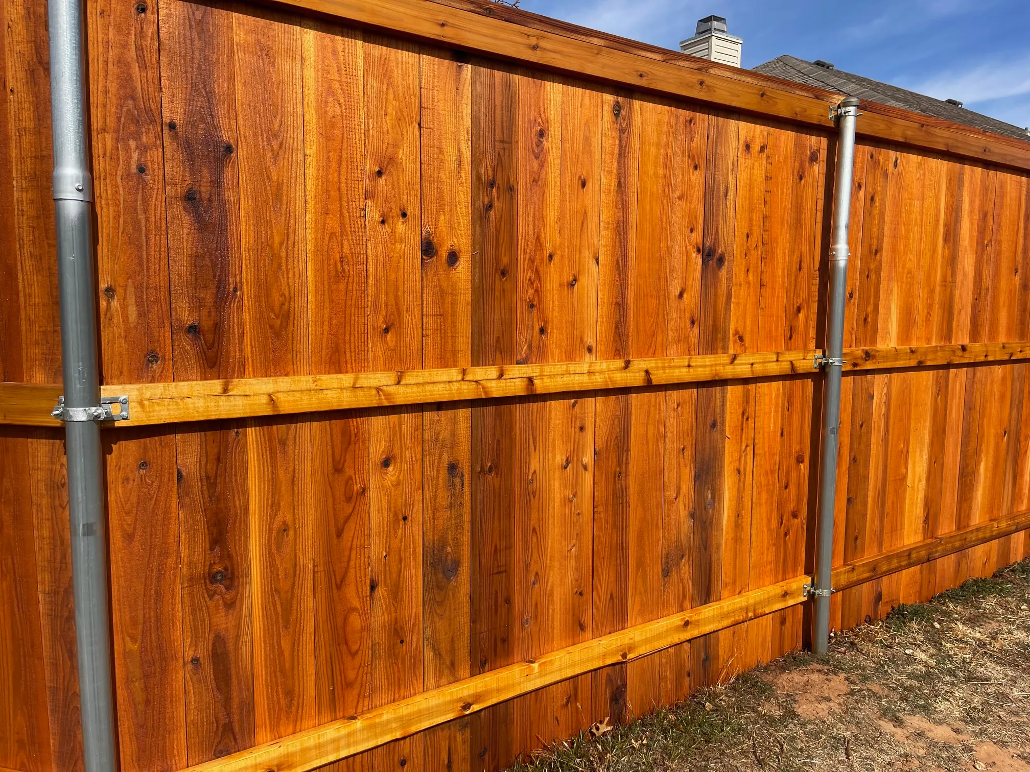 Straight run of stained cedar privacy fence with uniform top line
