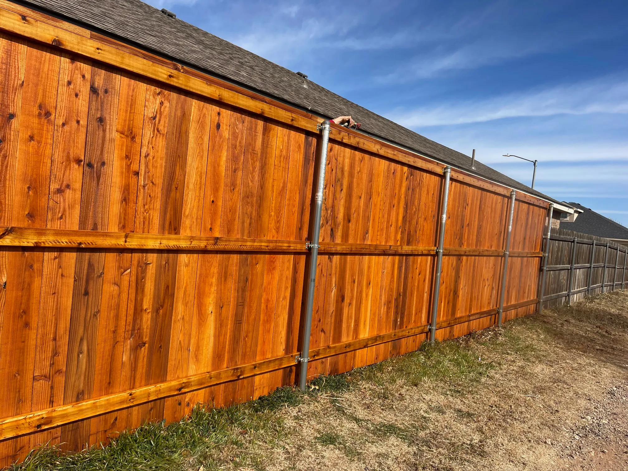 Color-matched stained cedar gate aligned with fence tone and finish
