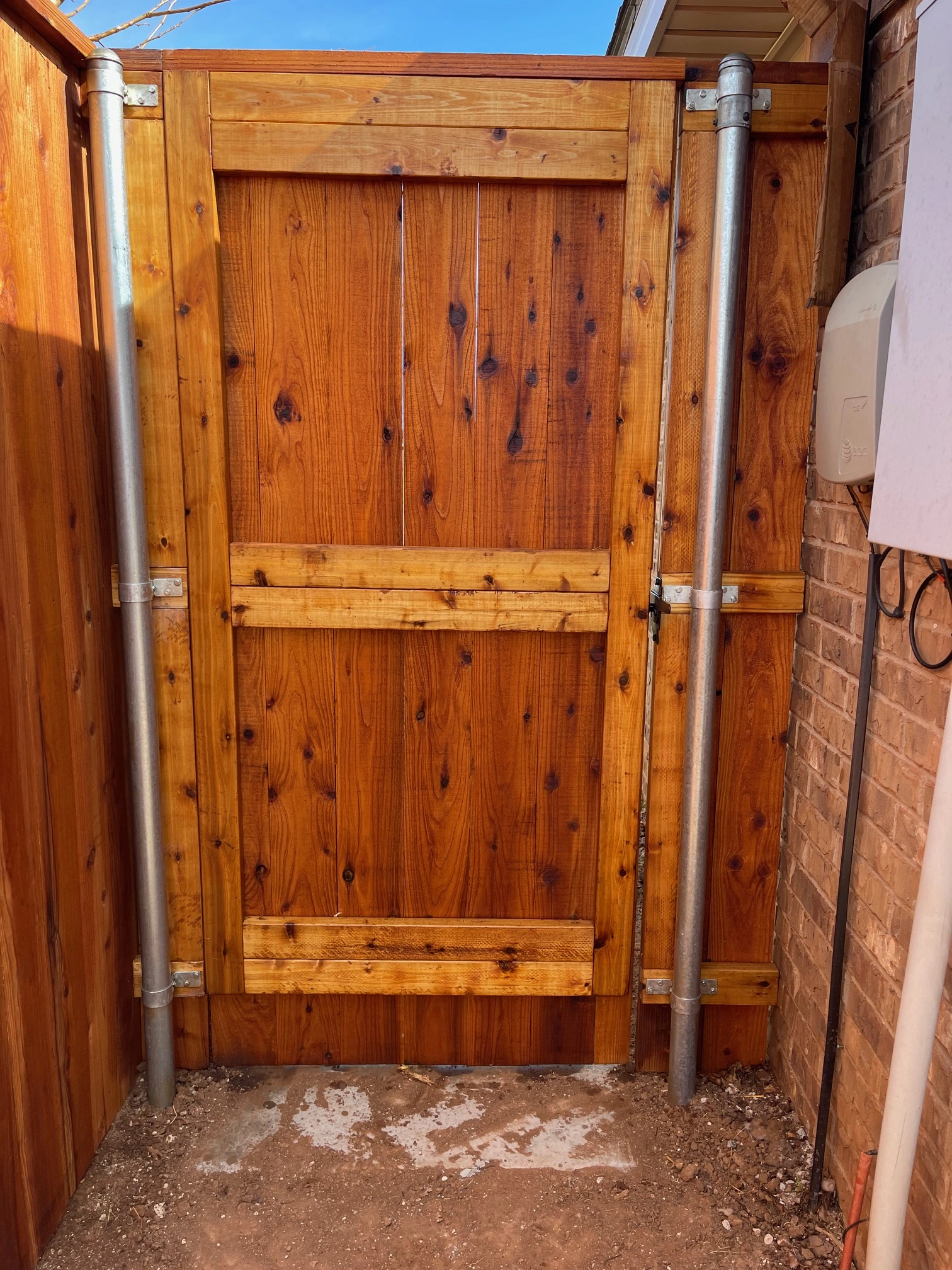 Five-foot-wide stained cedar gate with crown cap installed in Lubbock Texas