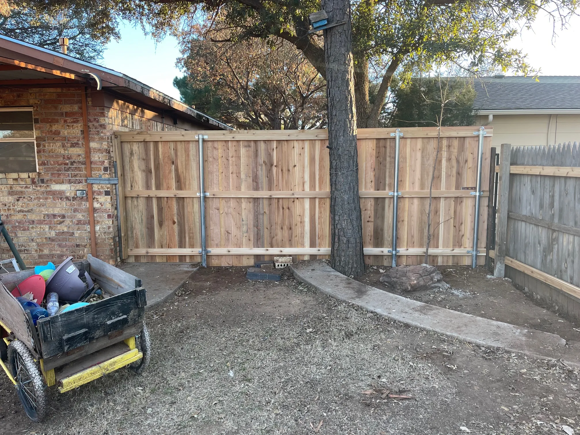 Cedar fence section with minimal bottom gaps for secure enclosure