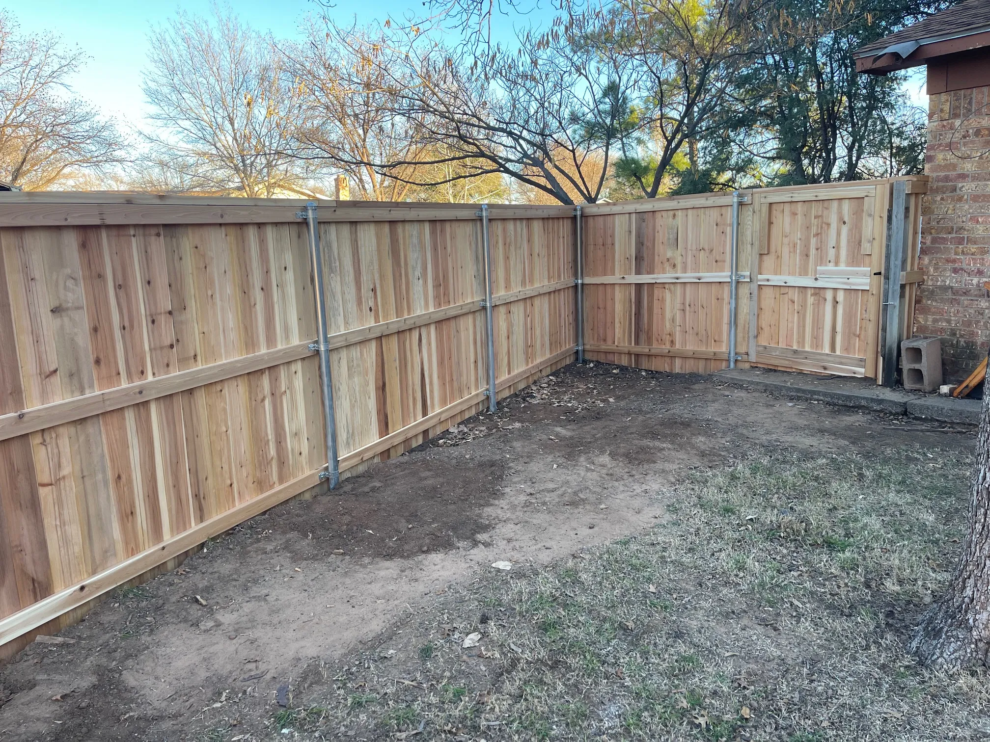 Freshly installed seven-foot cedar privacy fence with tight picket spacing
