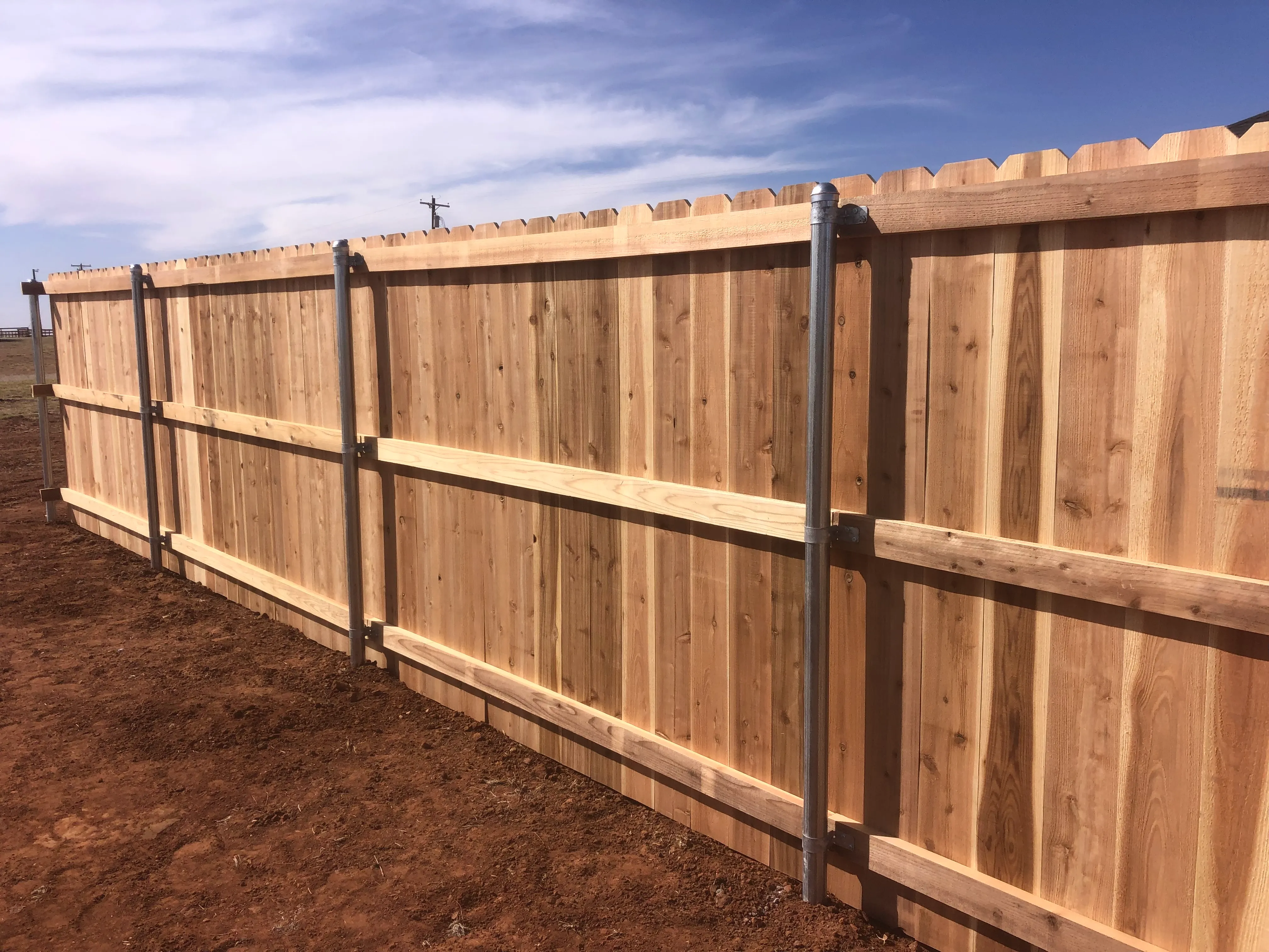Cedar fence height transition section maintaining level appearance