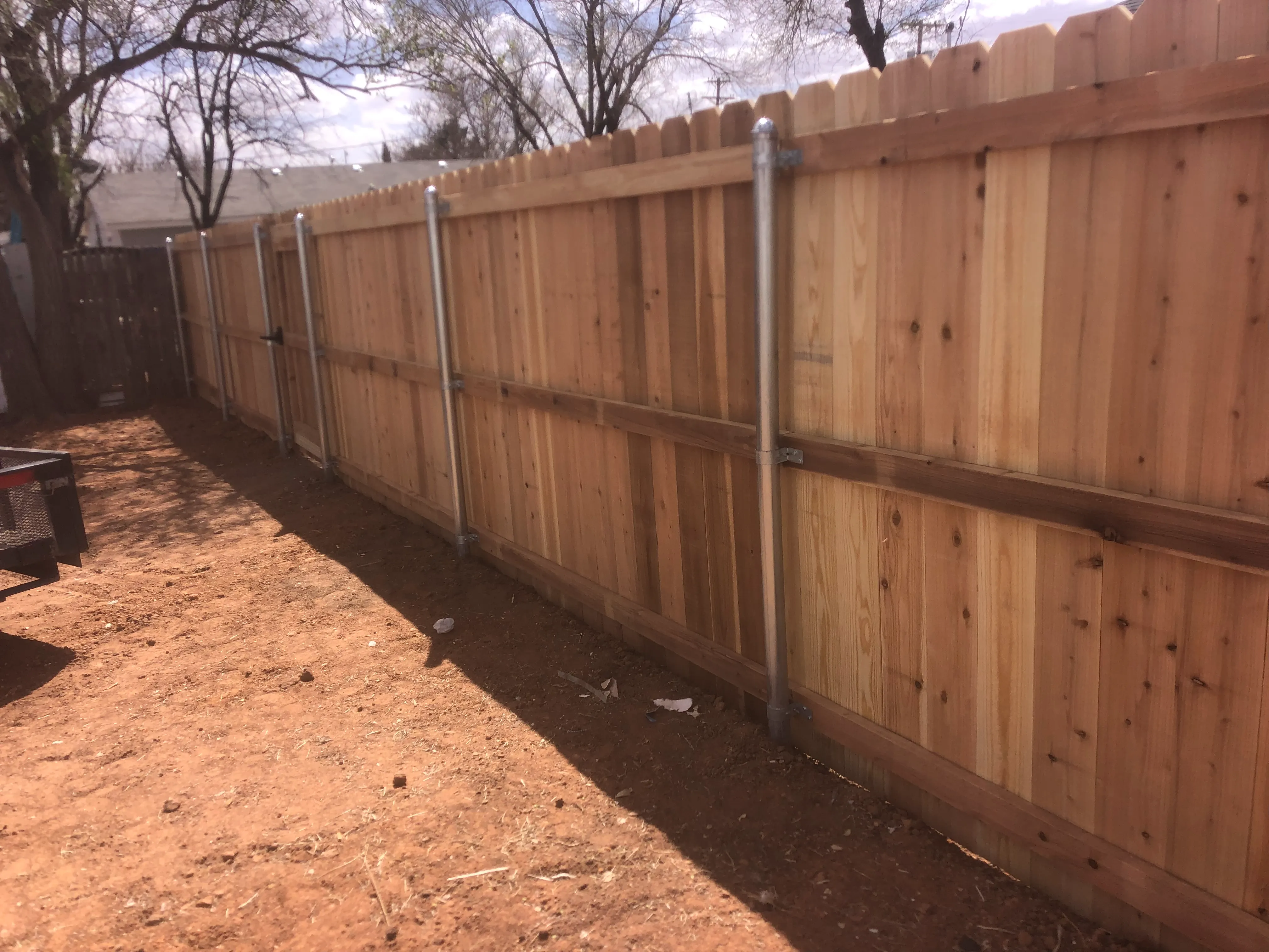 Tall cedar privacy fence with consistent dog-ear cut in Lubbock Texas