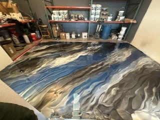 Custom epoxy floor design blends blues, silvers, and charcoal tones