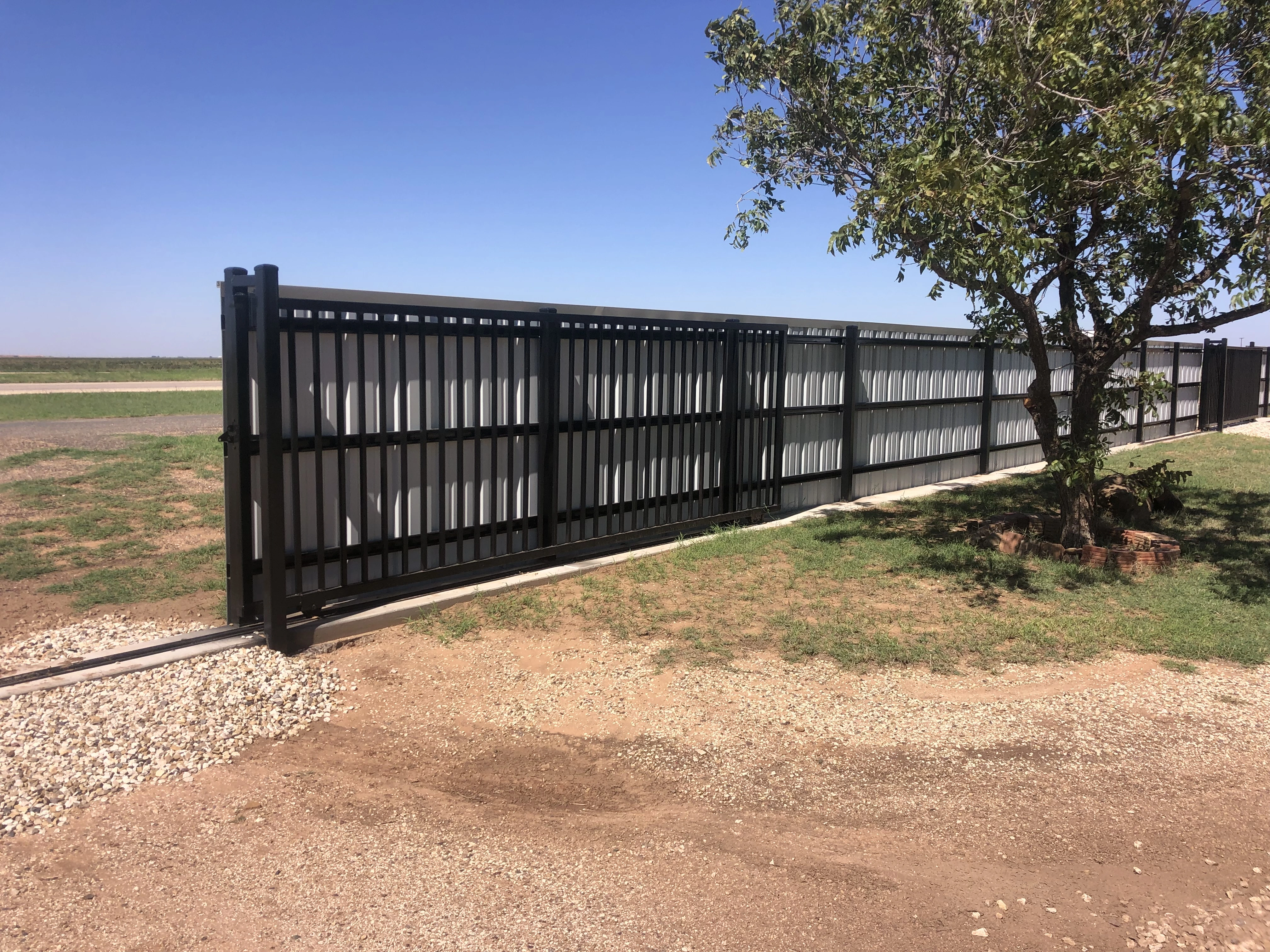 15-foot custom decorative steel slider gate built into matching metal fence system
