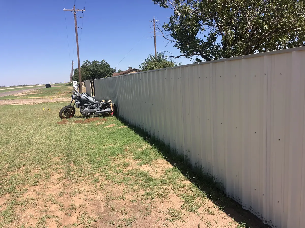 Twin automatic sliding metal gates paired with privacy fence in Light Stone color