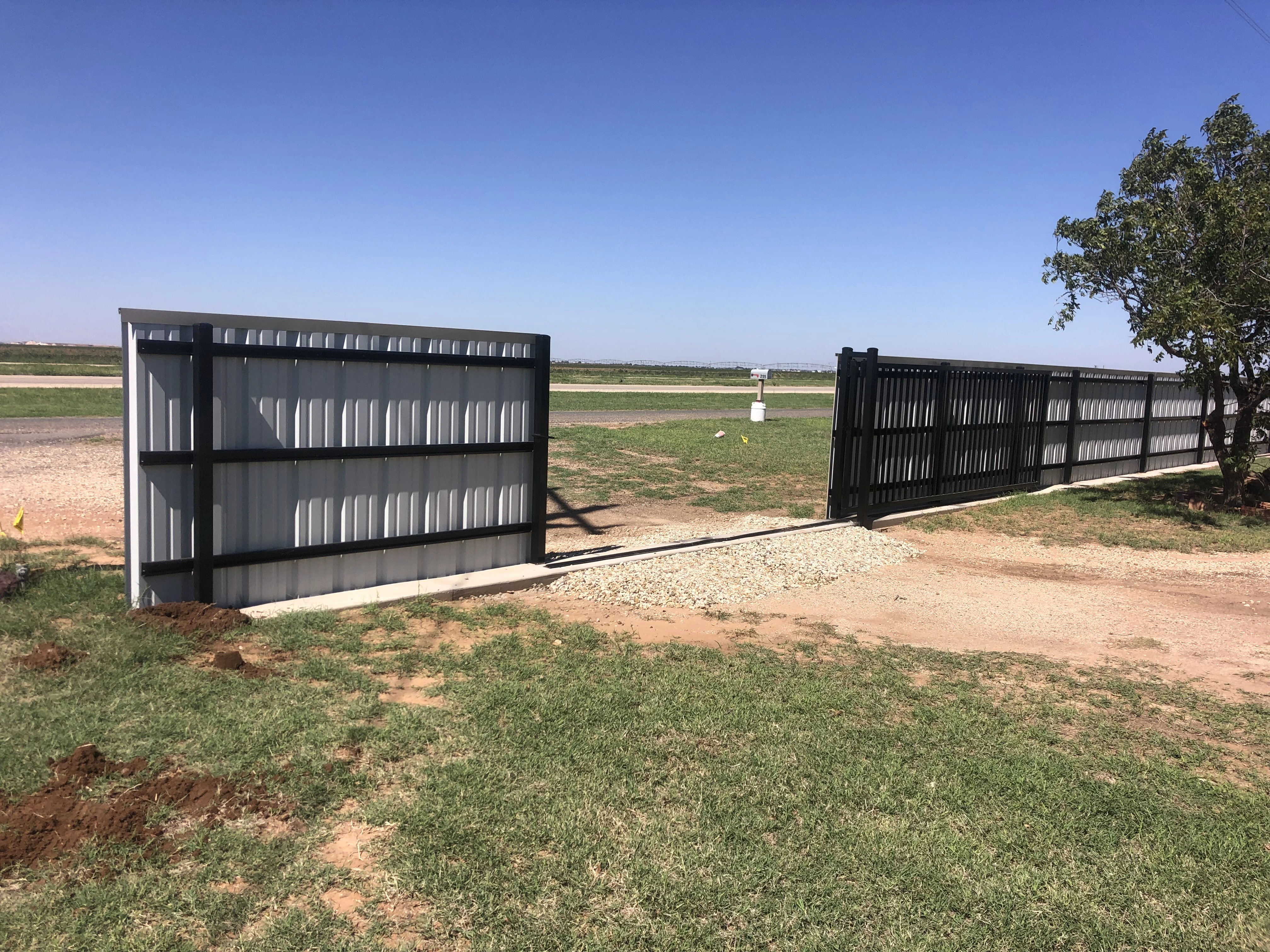 Powder-coated metal privacy fence with long-run welded panels installed in Lubbock Texas