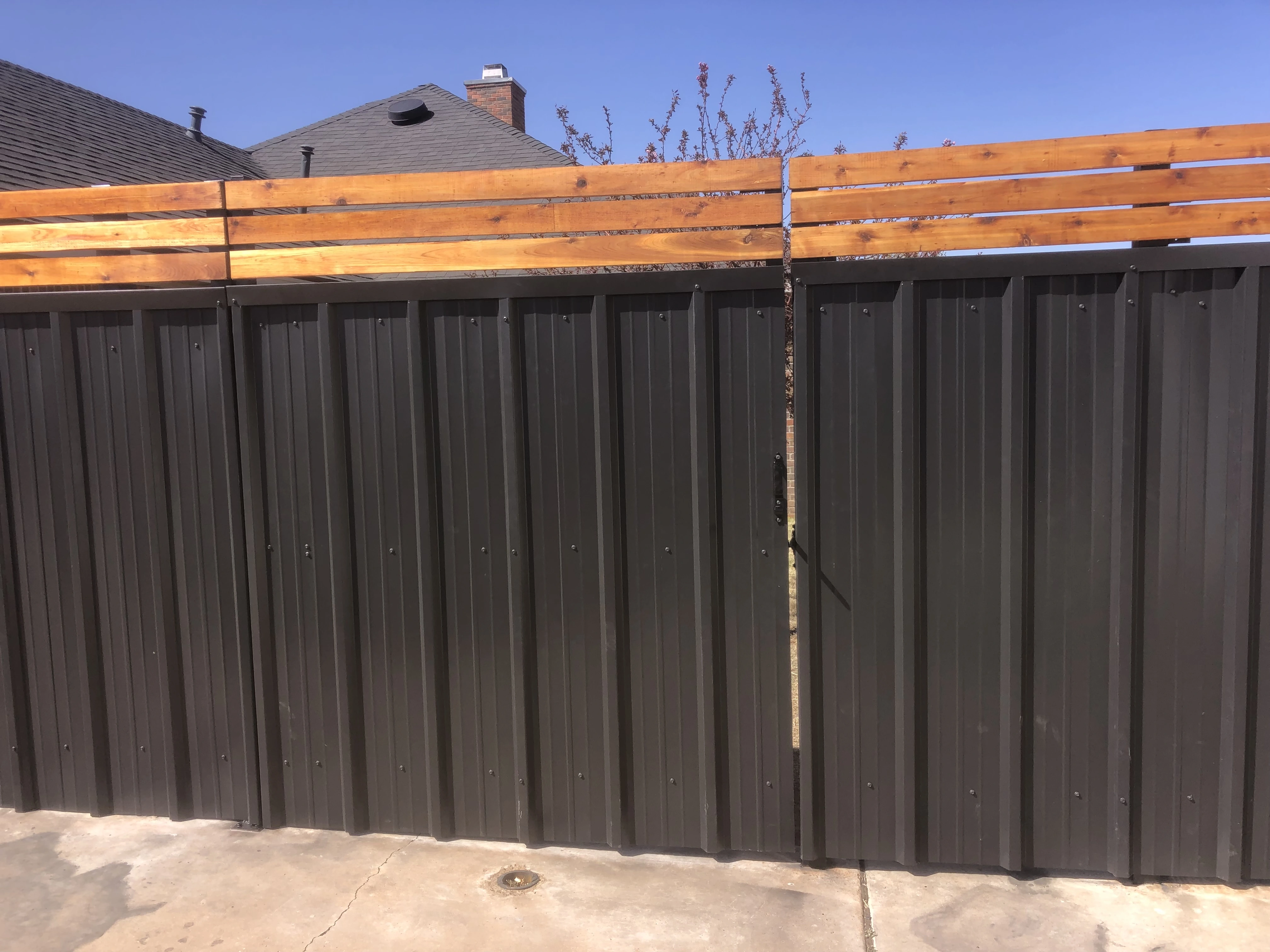 Close-up of steel frame and stained cedar planks used in hybrid privacy fence