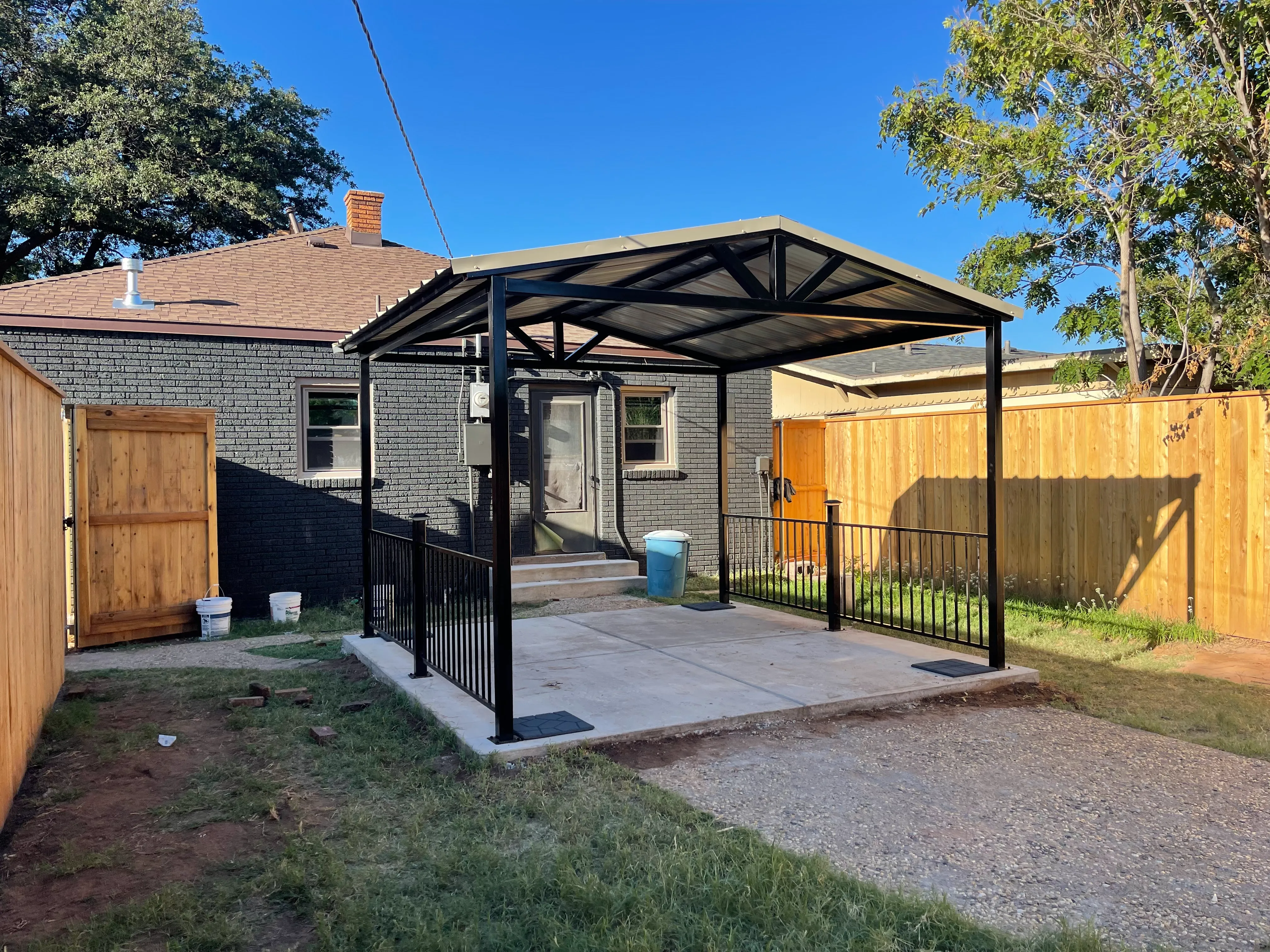 12 by 12 custom concrete pergola with dual decorative iron railings for backyard patio