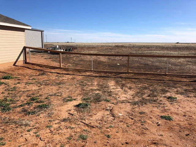 4-foot wood ranch rail fence with welded wire mesh fencing installed around a rural property featuring a custom double swing gate and durable livestock containment design