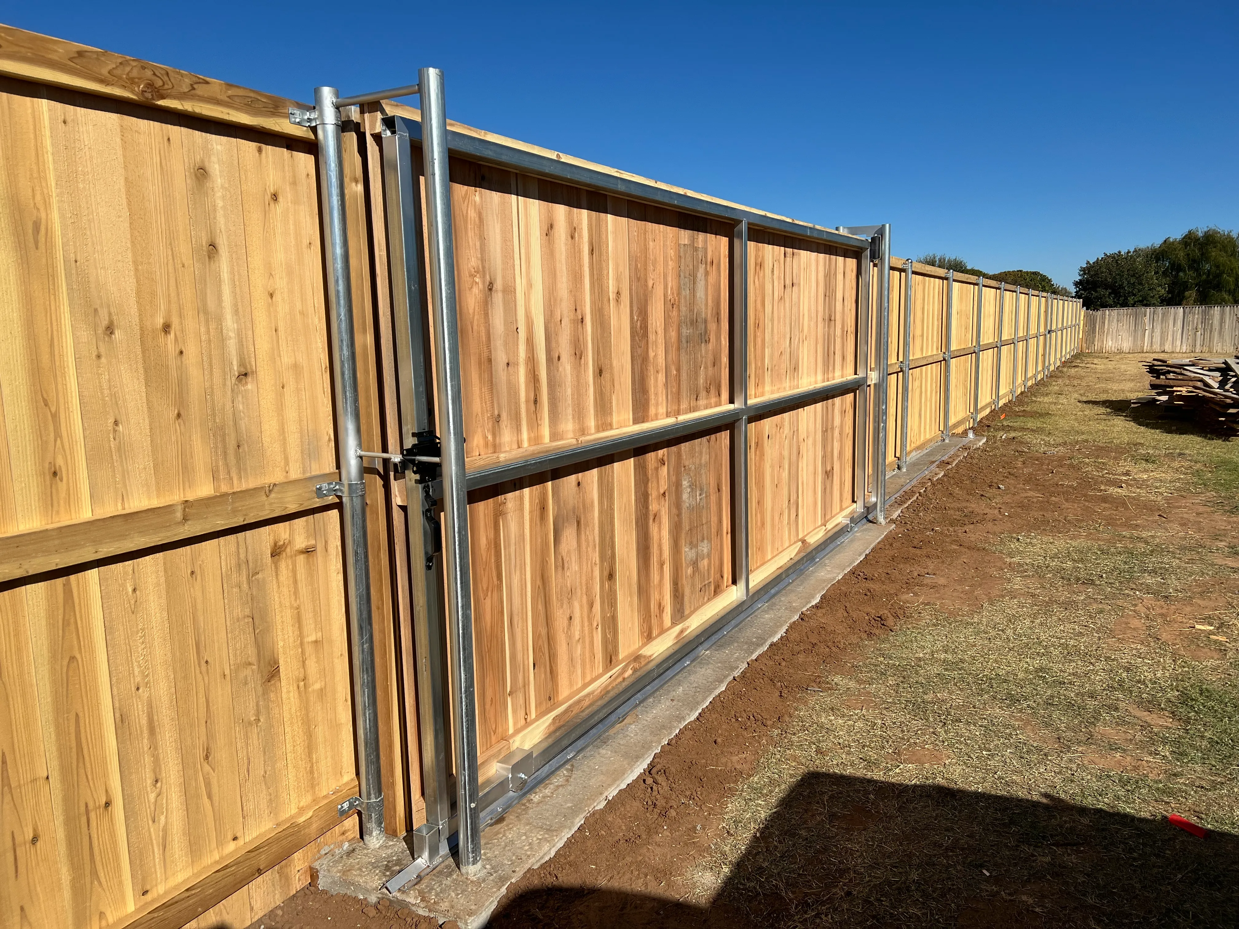 Heavy-duty steel slider gate post with ground track installed for smooth operation